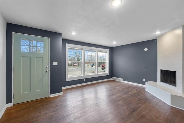 foyer featuring a fireplace and dark hardwood / wood-style floors