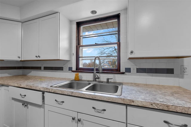 kitchen with tasteful backsplash, sink, and white cabinets