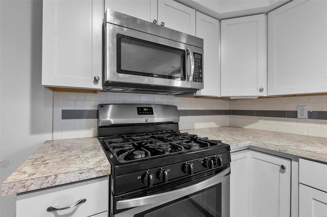 kitchen with white cabinetry, decorative backsplash, and stainless steel appliances