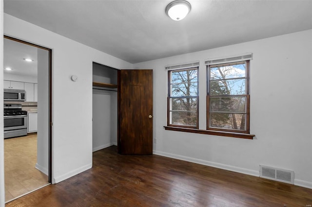 unfurnished bedroom featuring dark hardwood / wood-style floors and a closet