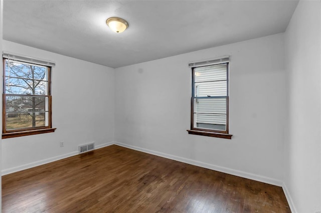 spare room with dark hardwood / wood-style flooring