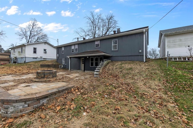 rear view of property with a fire pit