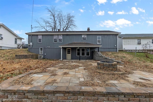 rear view of house with a patio area and a fire pit