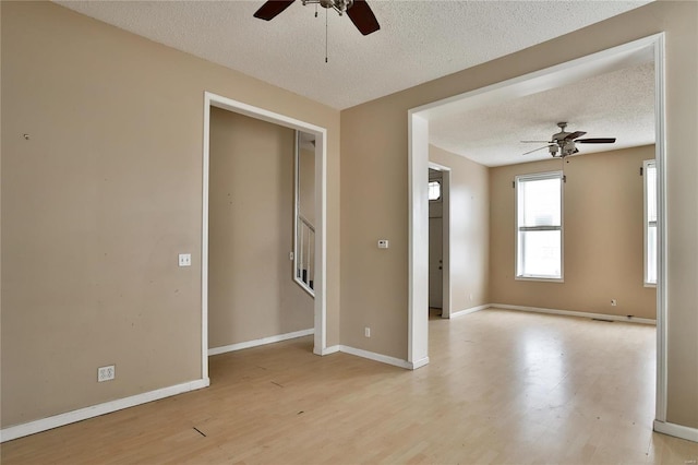 unfurnished room with ceiling fan, light hardwood / wood-style flooring, and a textured ceiling