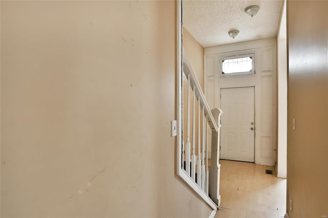 entryway featuring light hardwood / wood-style floors and a textured ceiling