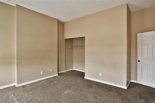 unfurnished bedroom with a closet, a textured ceiling, and dark colored carpet