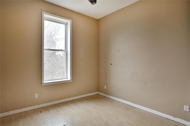 spare room featuring plenty of natural light and light hardwood / wood-style floors