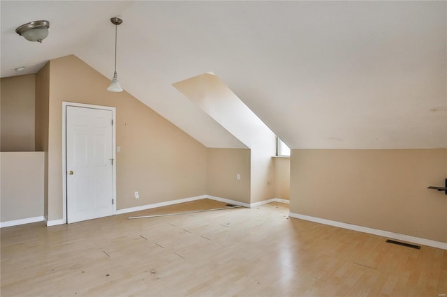 additional living space with lofted ceiling and light hardwood / wood-style floors