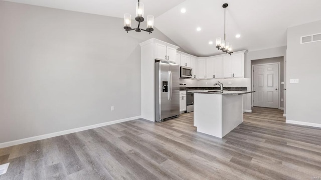 kitchen with stainless steel appliances, white cabinetry, a kitchen island with sink, and a chandelier