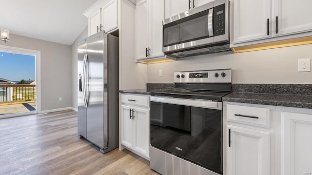 kitchen featuring white cabinetry, stainless steel appliances, light hardwood / wood-style floors, and dark stone countertops