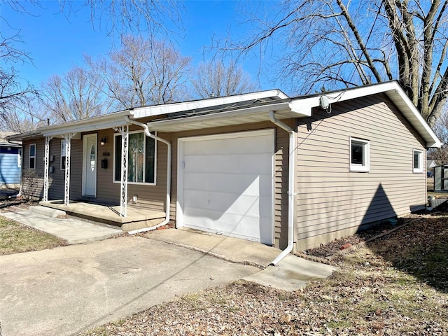 view of side of home with a garage, covered porch, and driveway