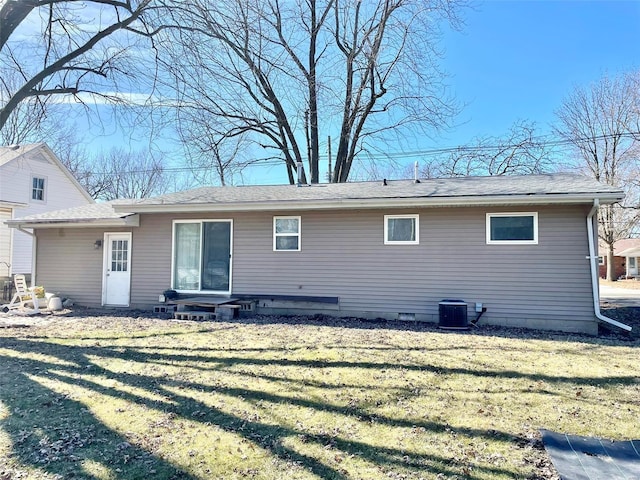 back of house with central AC and a lawn