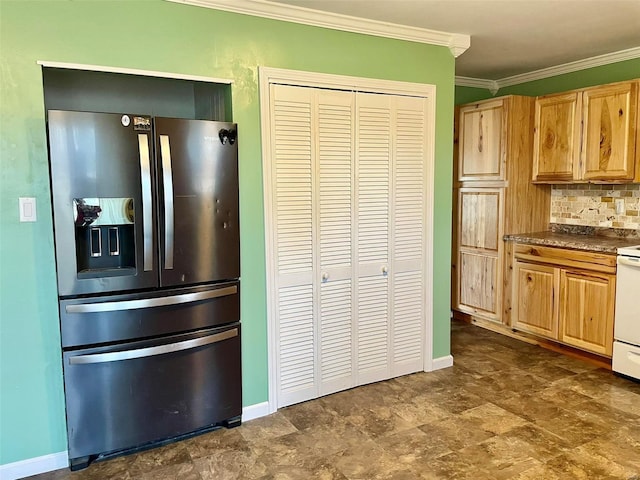 kitchen featuring baseboards, backsplash, stainless steel fridge, and crown molding