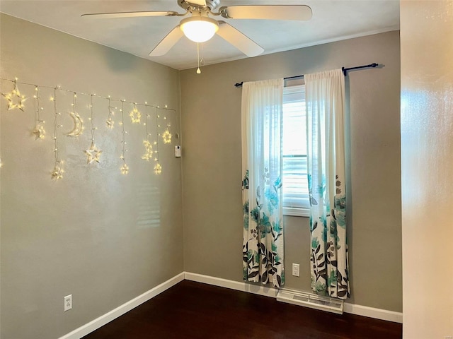 empty room featuring a ceiling fan, baseboards, and wood finished floors