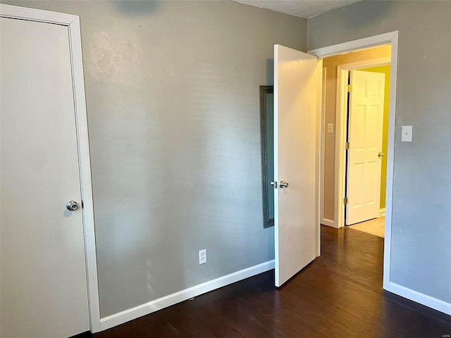 unfurnished bedroom featuring wood finished floors and baseboards