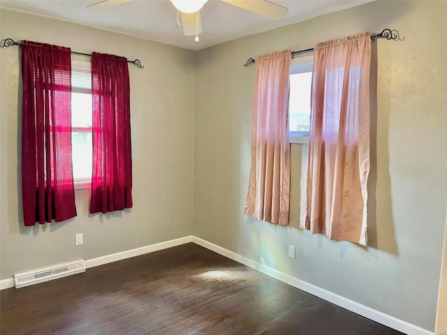 empty room with baseboards, visible vents, ceiling fan, and dark wood-style flooring