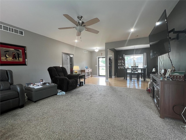 carpeted living room with ceiling fan