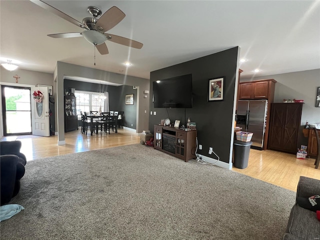 living room featuring light carpet and ceiling fan