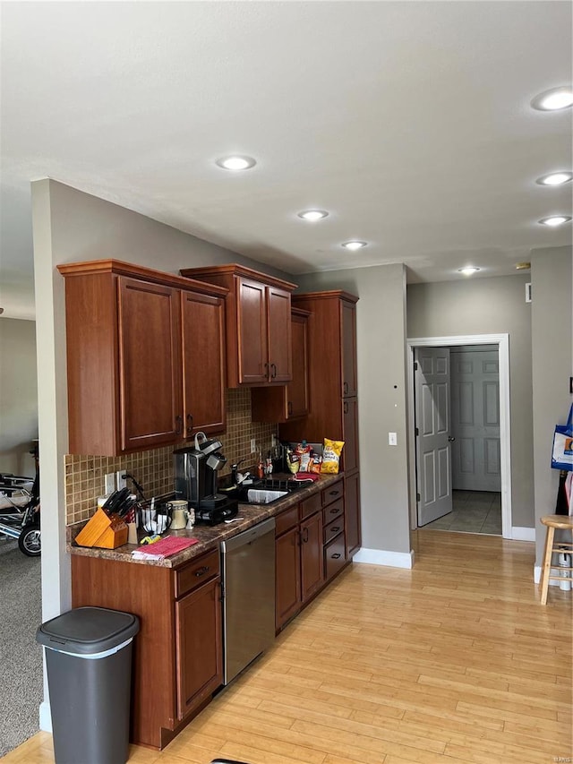 kitchen with dark stone countertops, dishwasher, decorative backsplash, and light hardwood / wood-style flooring