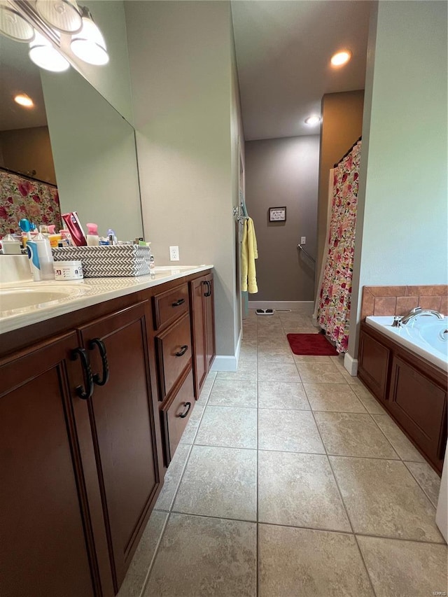 bathroom with a tub to relax in, vanity, and tile patterned flooring