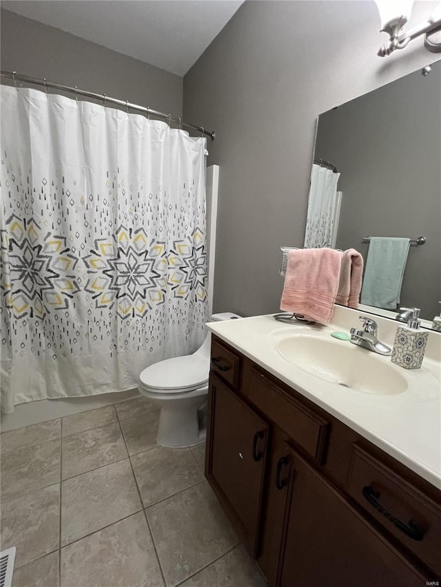 bathroom featuring tile patterned flooring, vanity, curtained shower, and toilet