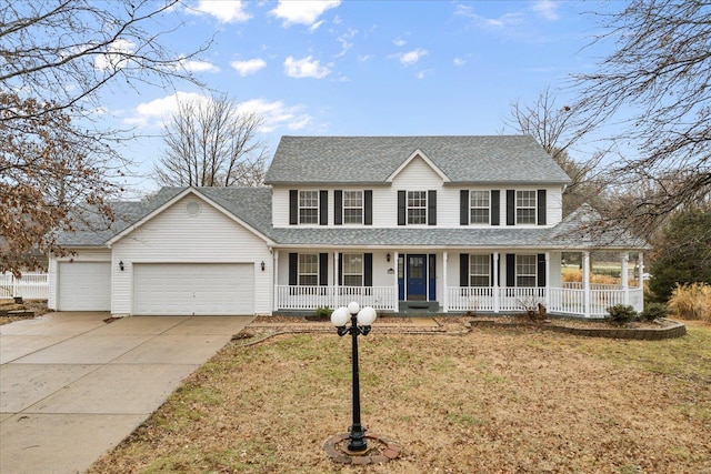 view of front of property with a garage, a front yard, and covered porch