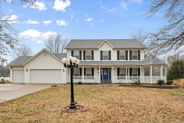 view of front of property with a garage, a front yard, and covered porch