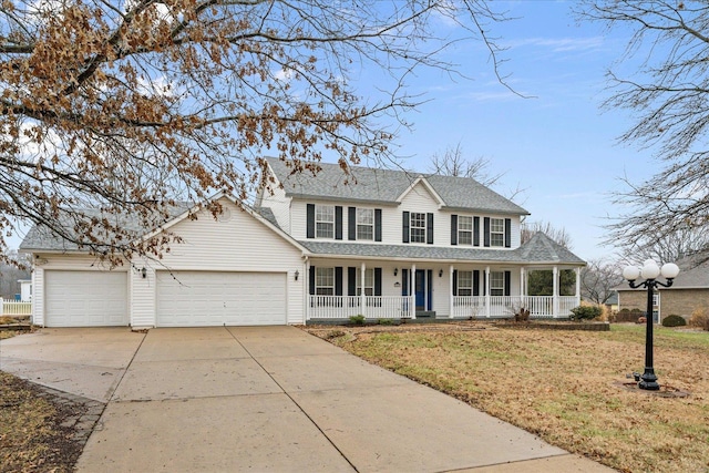 view of front of house featuring a garage, covered porch, and a front yard