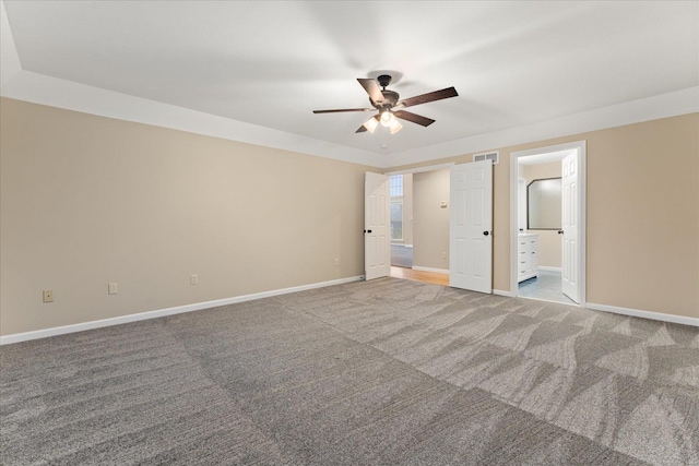 unfurnished bedroom featuring light carpet, ensuite bath, and ceiling fan