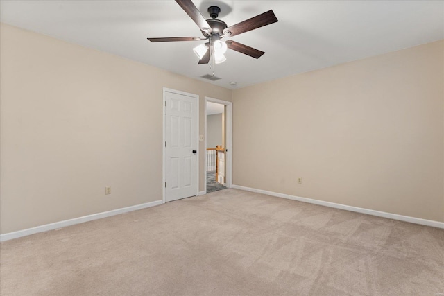 spare room with ceiling fan and light colored carpet