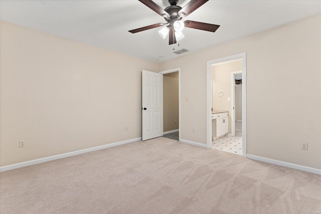 unfurnished bedroom with ceiling fan, light colored carpet, and ensuite bath