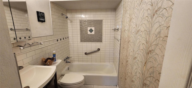 full bathroom with vanity, toilet, tiled shower / bath combo, and tile walls