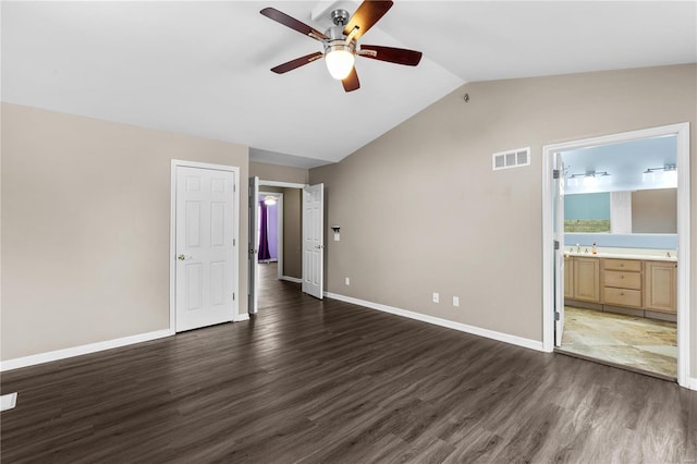 unfurnished bedroom with dark wood-type flooring, ceiling fan, lofted ceiling, and ensuite bathroom