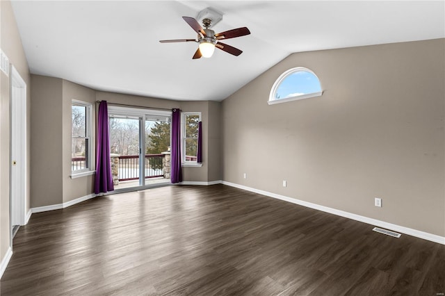 spare room featuring dark hardwood / wood-style flooring, a wealth of natural light, lofted ceiling, and ceiling fan