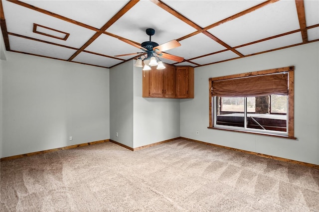 empty room featuring ceiling fan, coffered ceiling, and light carpet