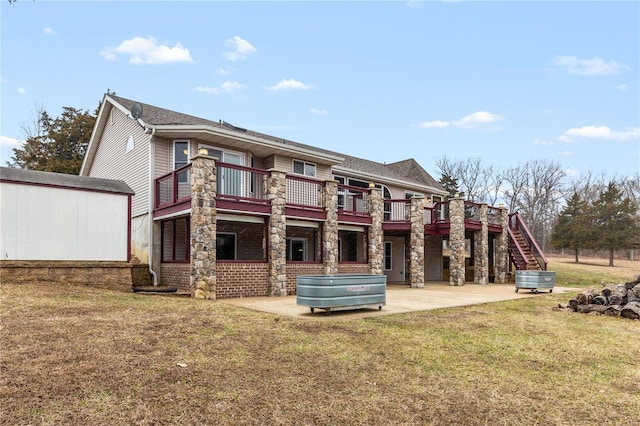 back of property featuring a balcony, a patio, and a lawn