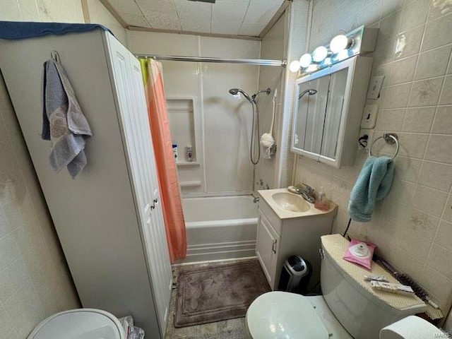 full bathroom with tile walls, vanity, toilet, and shower / bath combo with shower curtain