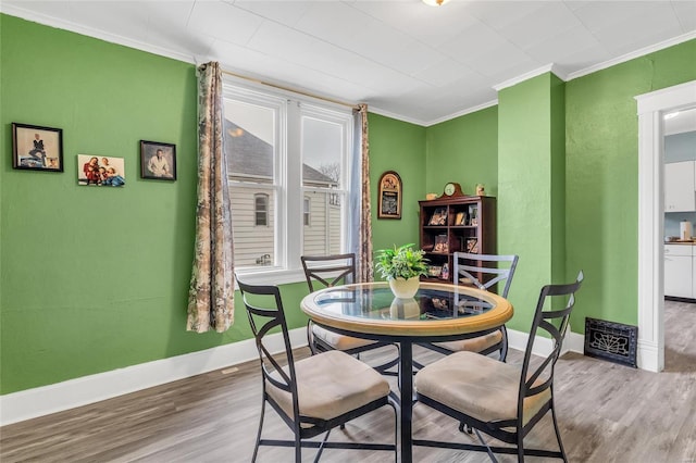 dining room with crown molding and wood-type flooring