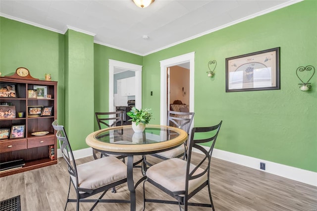 dining space featuring hardwood / wood-style floors and crown molding