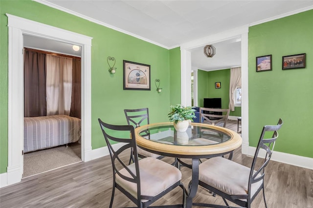 dining room with ornamental molding and hardwood / wood-style floors