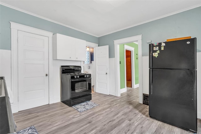 kitchen with white cabinetry, crown molding, black appliances, and light wood-type flooring