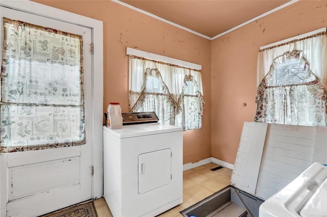 clothes washing area featuring crown molding, washer / dryer, and light tile patterned floors