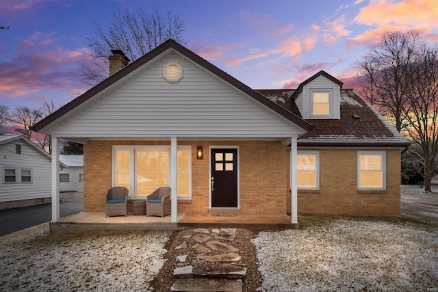 back house at dusk with a patio area