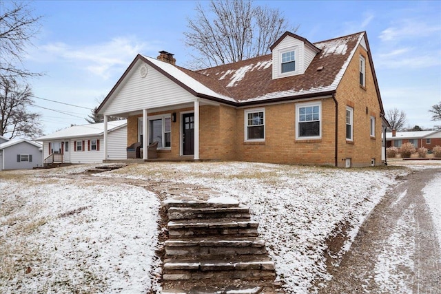 snow covered house featuring covered porch