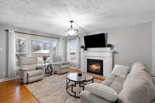 living room with hardwood / wood-style floors, a textured ceiling, and a chandelier