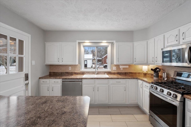 kitchen featuring stainless steel appliances, sink, white cabinets, and decorative backsplash