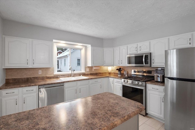 kitchen featuring white cabinetry, appliances with stainless steel finishes, sink, and a textured ceiling