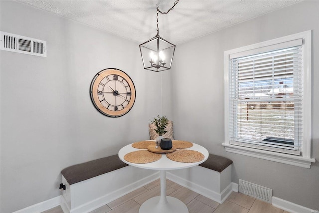 dining area with breakfast area, a chandelier, and a textured ceiling