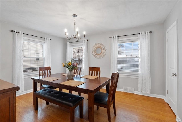 dining room featuring an inviting chandelier, plenty of natural light, and light wood-type flooring