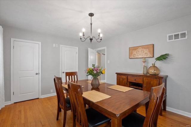 dining space with a notable chandelier and light hardwood / wood-style flooring